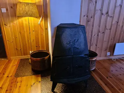 a living room with a black chair and a lamp at Hyttepreget overnattingssted in Geilo