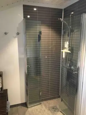 a bathroom with a shower with a glass door at Hytte med god standard in Stranda
