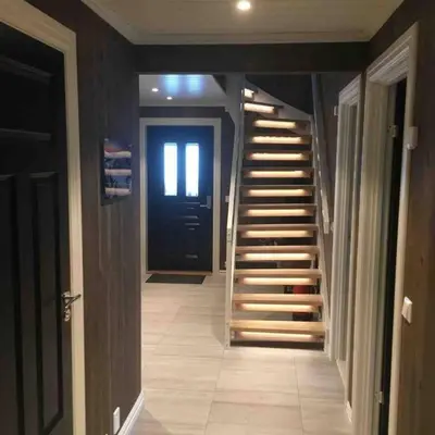 a hallway with stairs leading to a black door at Hytte med god standard in Stranda