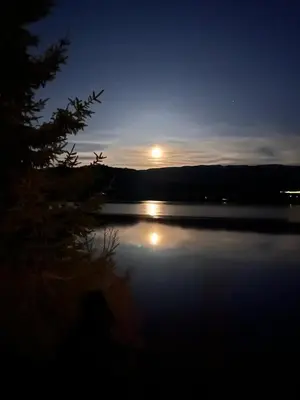 a moon rising over a lake at night at Magnar in Etnesjøen