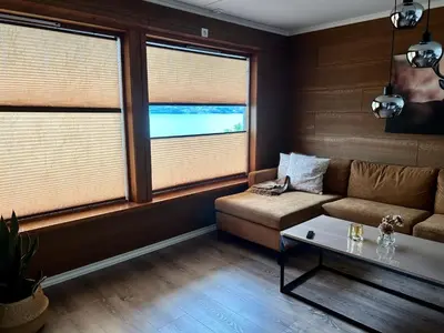 a living room with a couch and two windows at Magnar in Etnesjøen