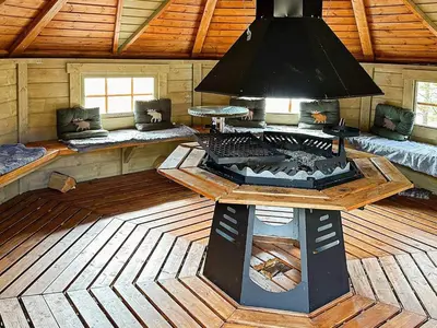 a large room with a fireplace in a wooden cabin at 4 person holiday home in Lysøysundet in Teksdal