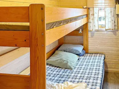 a bunk bed in a wooden cabin with a bunk bedsheet at 4 person holiday home in Lysøysundet in Teksdal