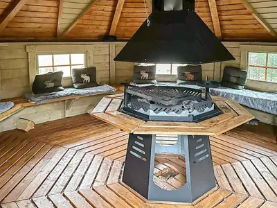 a large room with a stove in a cabin at 4 person holiday home in Lysøysundet in Teksdal