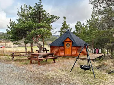 a wooden cabin with a picnic table and a swing at 4 person holiday home in Lysøysundet in Teksdal