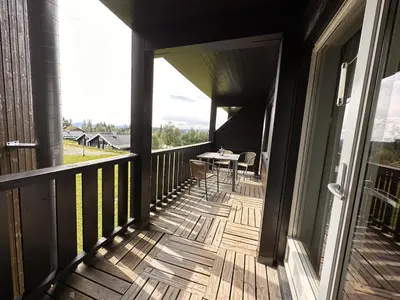 a balcony of a house with a table on it at Ideal Base For Exploring 2 Bedrooms & Balcony in Beitostøl