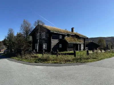 an old house with a grass roof on a street at Geilo centrum - cozy apartment - central location in Geilo
