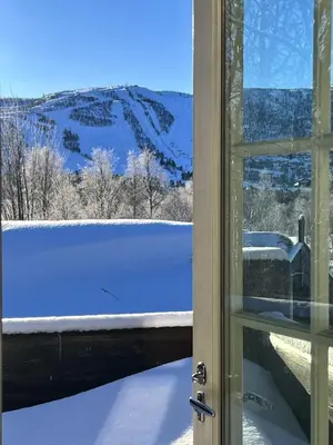 a view of a snow covered field through a window at Geilo centrum - cozy apartment - central location in Geilo