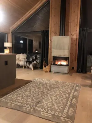 a living room with a fireplace and a rug at Golsfjellet - new modern cabin with fantastic view in Golsfjellet