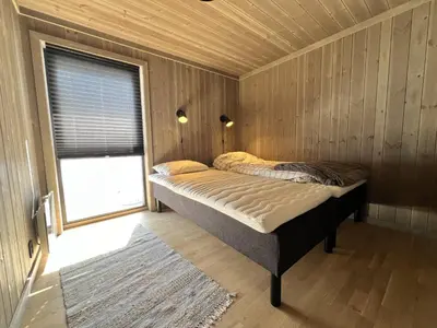 a bedroom with a bed in a room with a window at Golsfjellet - new modern cabin with fantastic view in Golsfjellet