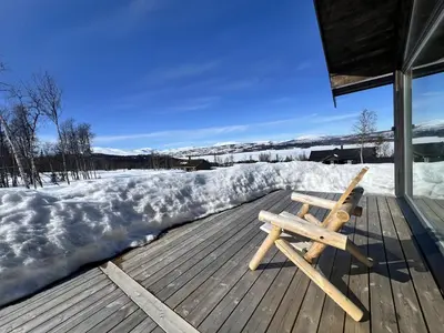 a wooden bench sitting on a deck in the snow at Golsfjellet - new modern cabin with fantastic view in Golsfjellet