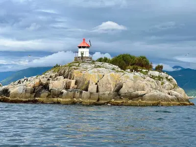 a lighthouse on an island in the water at Fjord-Holiday-Lodge mit atemberaubendem Panorama in Åfarnes