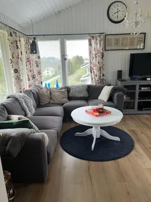 a living room with a couch and a table at Holiday Home Sletta in Sletta