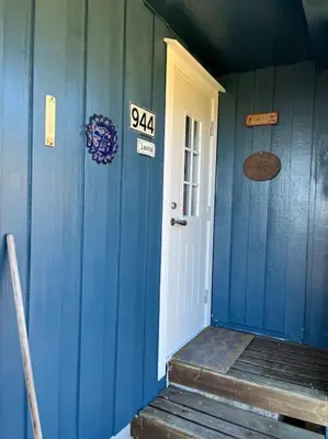a blue house with a blue door and stairs at Holiday Home Sletta in Sletta