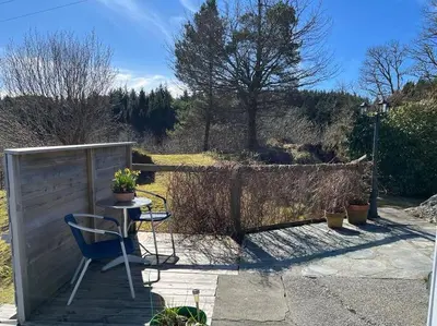 a table and a chair on a patio at Holiday Home Sletta in Sletta