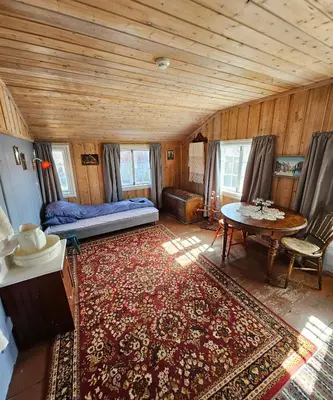 a living room with a bed and a table at Private pearl in downtown Røros in Røros