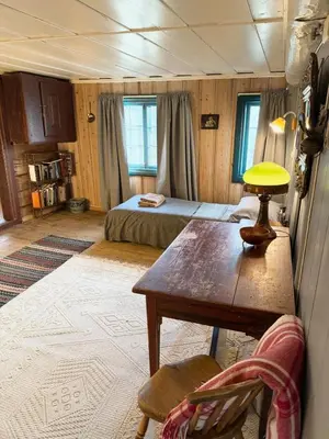 a bedroom with a bed and a table in a room at Private pearl in downtown Røros in Røros