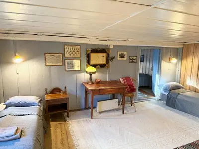 a room with two beds and a desk and a bedroom at Private pearl in downtown Røros in Røros