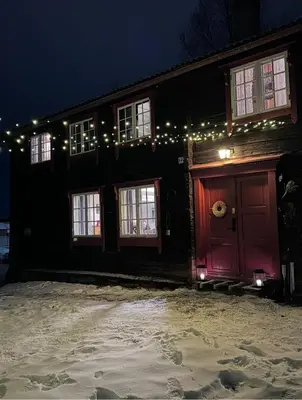 a house with a red door with christmas lights at Private pearl in downtown Røros in Røros
