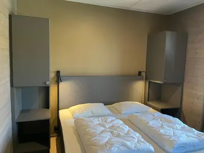 a bed in a room with two open cabinets at Riddertunets utsikt til Slettefjell in Beitostøl