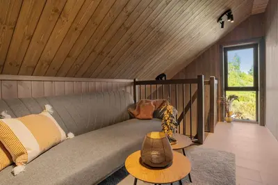 a couch in a room with a wooden ceiling at Stryn Wiew Logde Tverrfjellet in Stryn