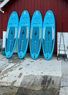four blue surfboards lined up against a red wall at Studio apartment in Sogndal