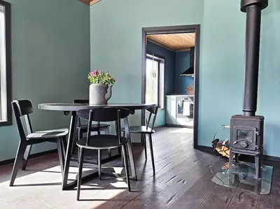 a dining room with a table and a wood stove at Cozy Mountain Cottage with beautiful views & Sauna in Beitostøl