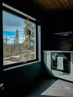 a kitchen with a window with a view of the mountains at Cozy Mountain Cottage with beautiful views & Sauna in Beitostøl