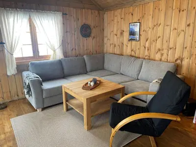 a living room with a couch and a table at Springaren - cabin close to Gaustatoppen in Tuddal