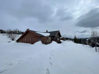 a house in the snow with footprints in the snow at Springaren - cabin close to Gaustatoppen in Tuddal