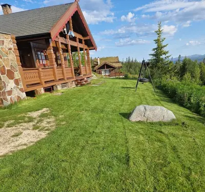 a log cabin with a rock in the yard at Springaren - cabin close to Gaustatoppen in Tuddal