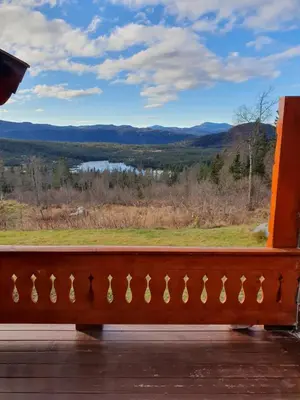 a bench on a porch with a view of the mountains at Springaren - cabin close to Gaustatoppen in Tuddal
