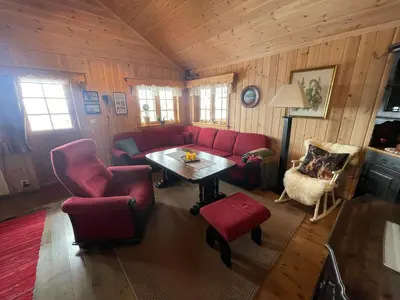 a living room with red furniture and a table at Springaren - cabin close to Gaustatoppen in Tuddal