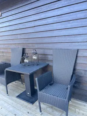 a table with two chairs and a table with candles on it at Koselig gårdshus in To