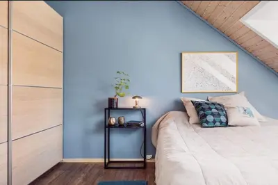 a bedroom with blue walls and a bed at Nydelig leilighet i Bakklandet in Trondheim