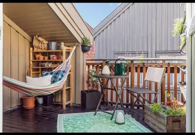 a porch with a hammock and a table and chairs at Nydelig leilighet i Bakklandet in Trondheim