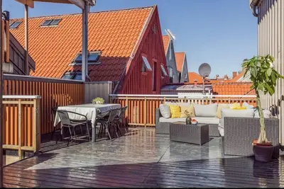 a patio with a couch and a table and chairs at Nydelig leilighet i Bakklandet in Trondheim