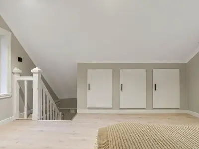a white bedroom with white doors and a staircase at Stay l The Town House in Bergen