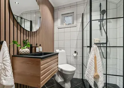 a bathroom with a toilet and a sink and a mirror at Stay l The Town House in Bergen