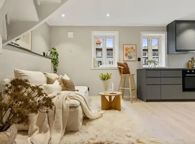 a living room with a couch and a kitchen at Stay l The Town House in Bergen