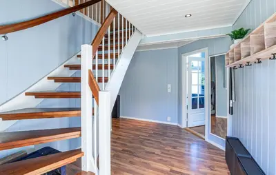 a staircase in a home with blue walls and wooden floors at 5 Bedroom Lovely Home In Ølensvåg in Vaka