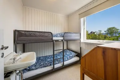 two bunk beds in a room with a sink and a window at Villa Ocean View in Askøy