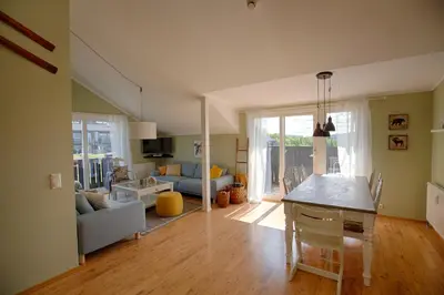 a kitchen and living room with a table and a couch at Bright and Modern penthouse apartment in Beitostøl