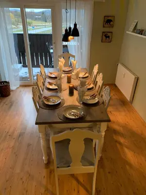 a dining room table with chairs and a wooden floor at Bright and Modern penthouse apartment in Beitostøl
