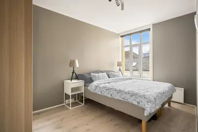 a white bedroom with a bed and a window at Bergen Beds Apartments I Luxury 250m from Bryggen in Bergen