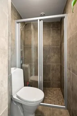 a bathroom with a toilet and a shower at Bergen Beds Apartments I Luxury 250m from Bryggen in Bergen