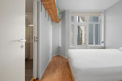 a bedroom with a white bed and a window at Your Local Bergen Dream In The Heart Of The city in Bergen