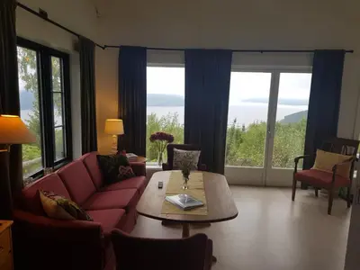 a living room with a couch and a table and windows at Annex Fjara greater Oslos best view sleeps 10 guests in 3 bedrooms in Stange