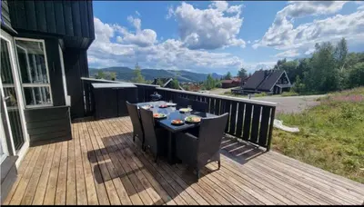 a wooden deck with a table with food on it at Alpinvegen 22B, Trysil Alpin 22B in Trysil