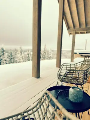 two benches sitting on a porch with a table at Snowcake Cottage in Sør-Fron